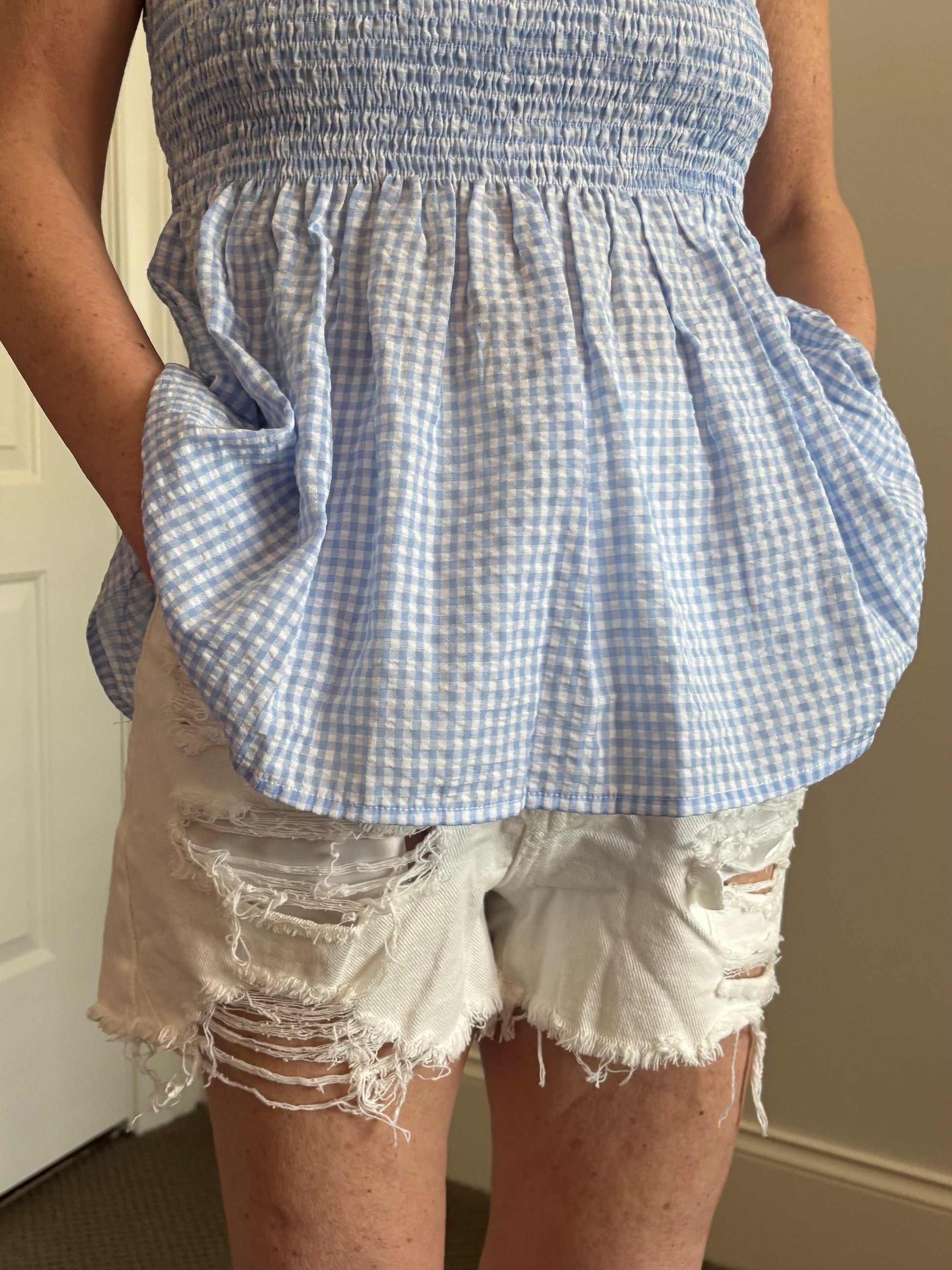Woman wearing white distressed denim shorts