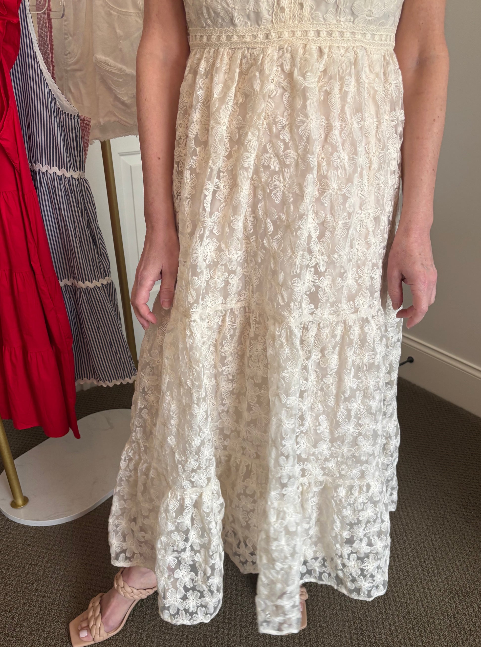 Woman wearing a white, creamy lace maxi dress.