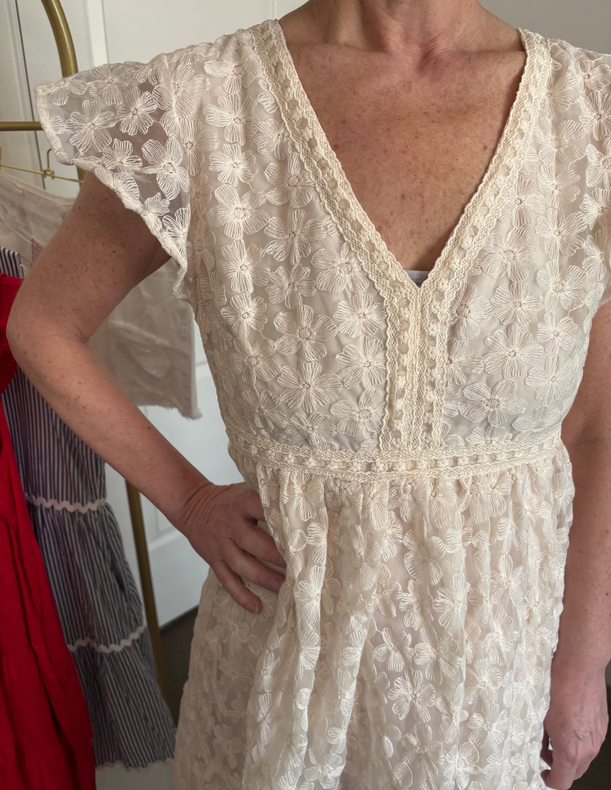 Woman wearing a beige lace dress with a blurred background