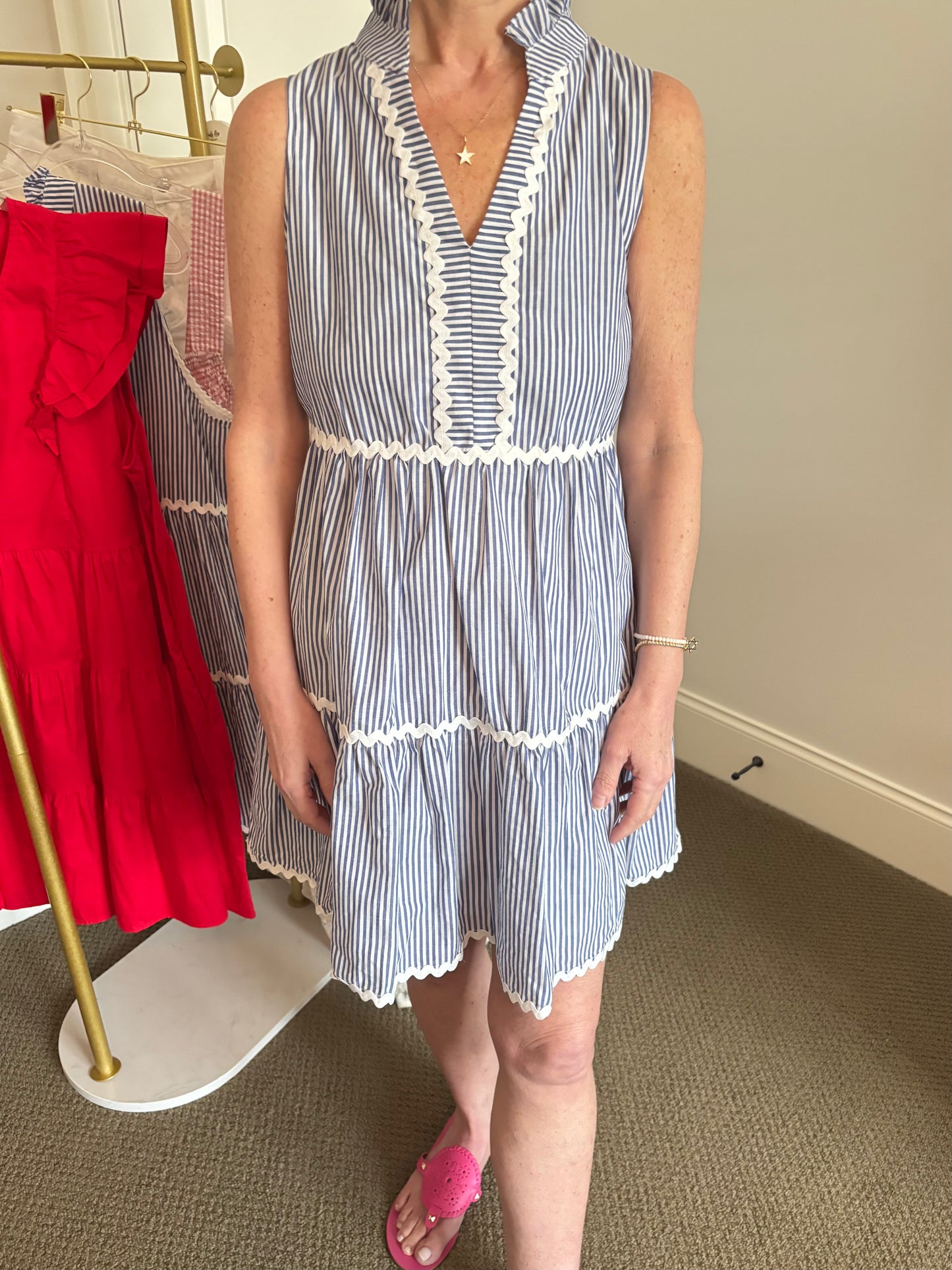 Woman wearing a blue and white striped dress with a plain background