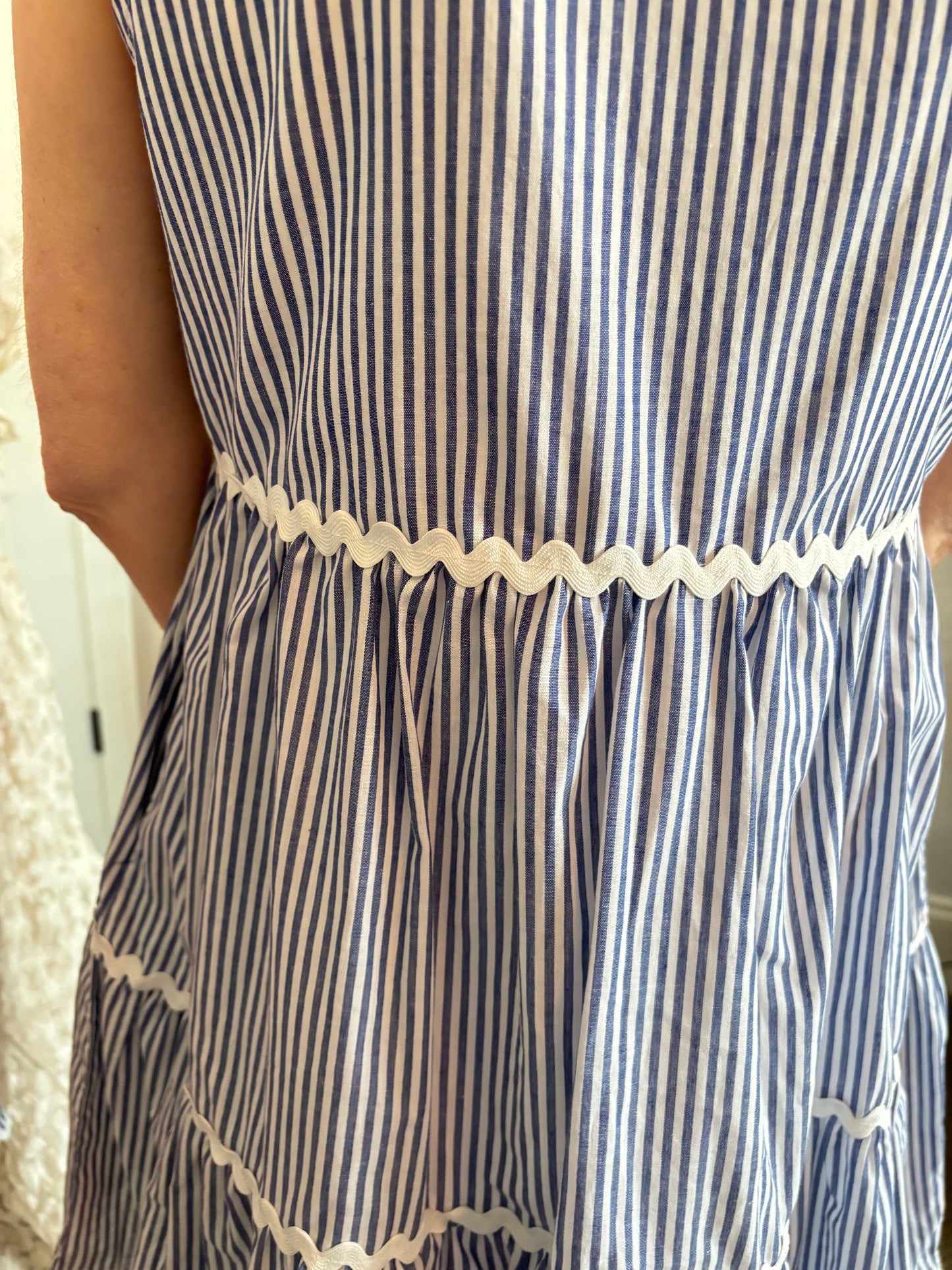 Close-up of a blue and white striped dress with lace trim.