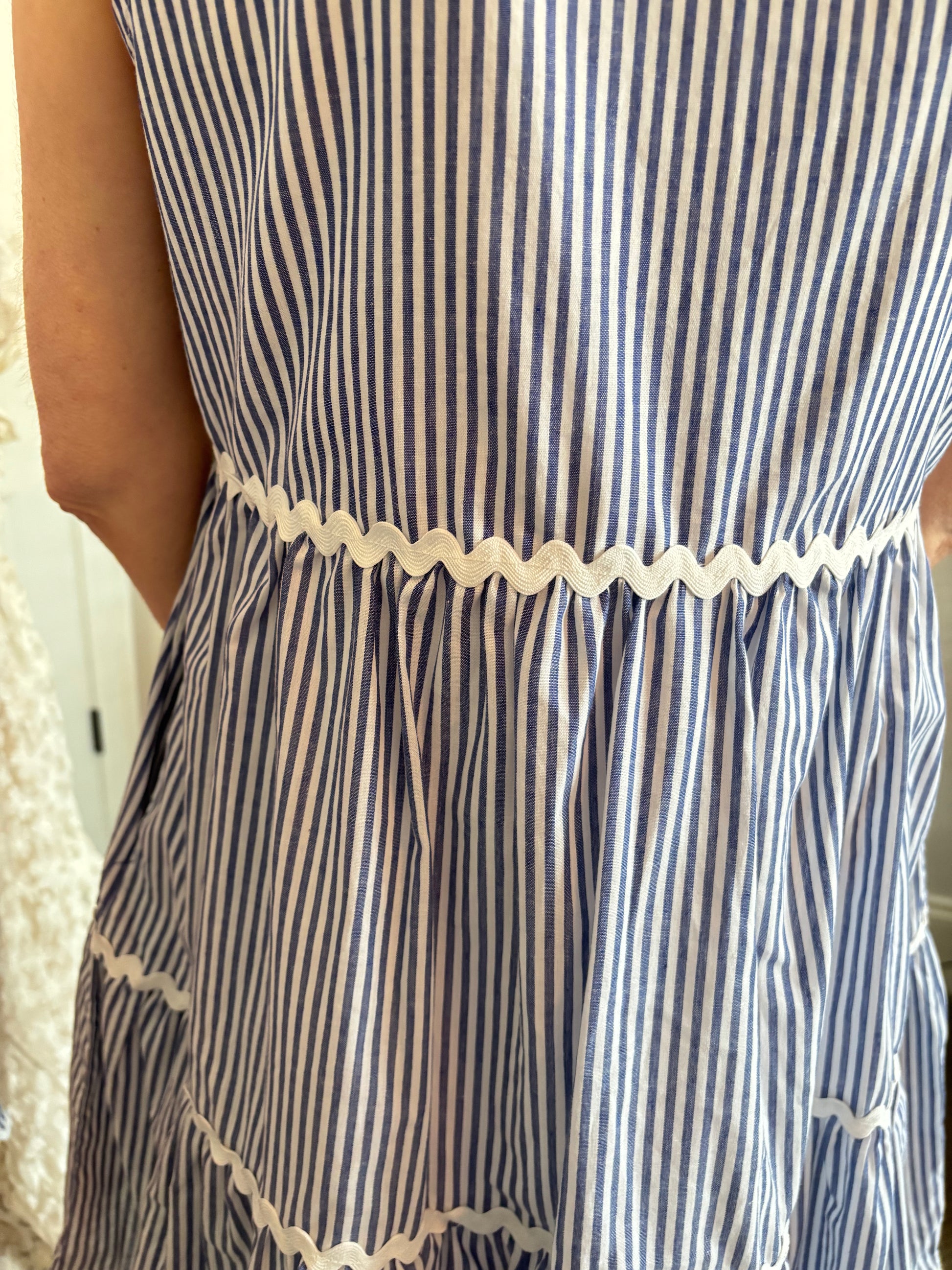 Close-up of a blue and white striped dress with lace trim.
